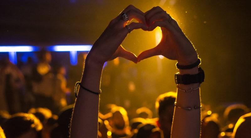 Mani a cuore in un concerto scoperto tramite siti di prenotazione eventi